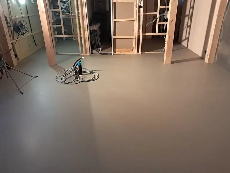 Betonggulv under ferdigstillelse i et byggeprosjekt med trevegger.